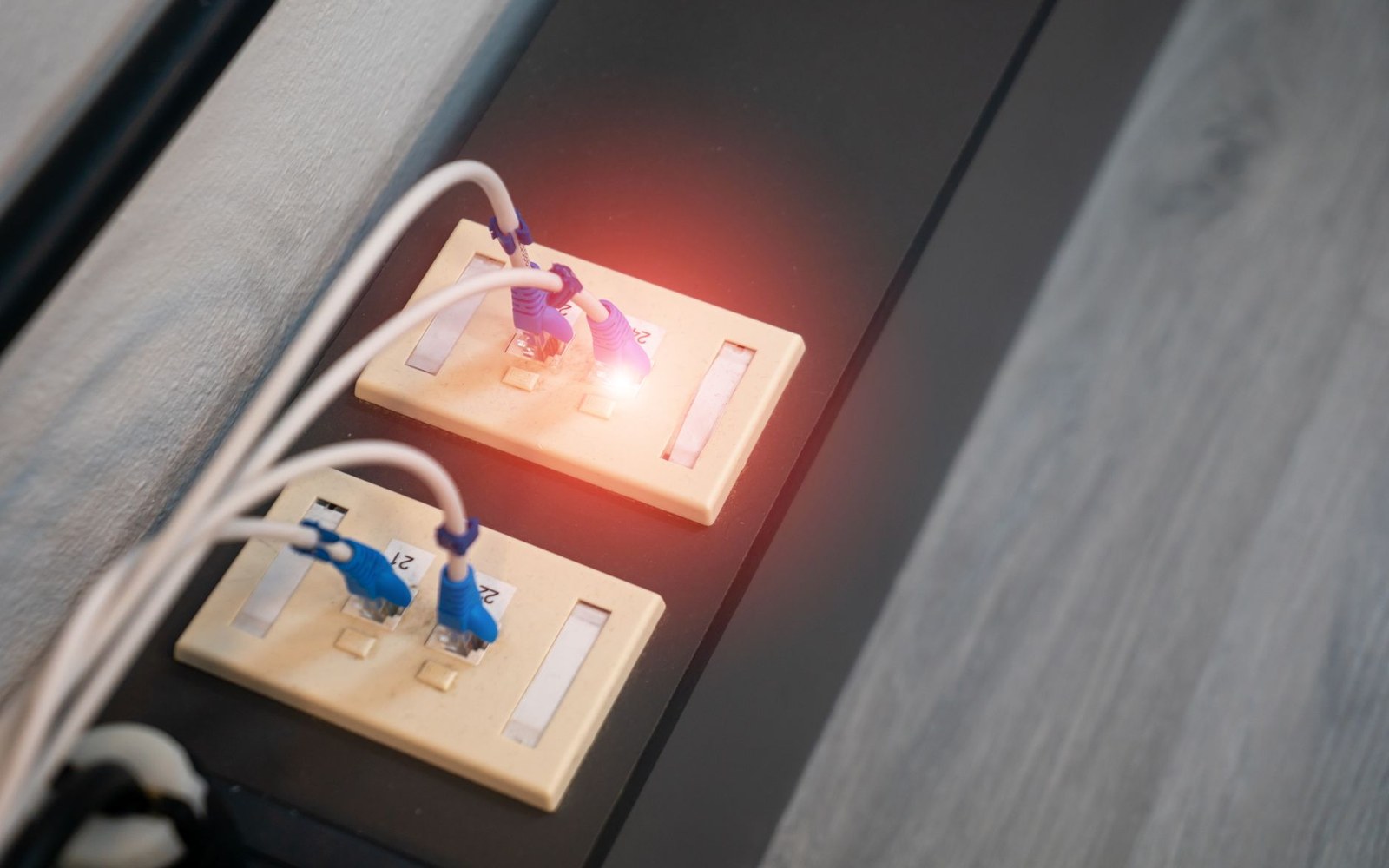 Small self-hosted server on a home-office shelf with ethernet cables routed neatly, indicator lights lit